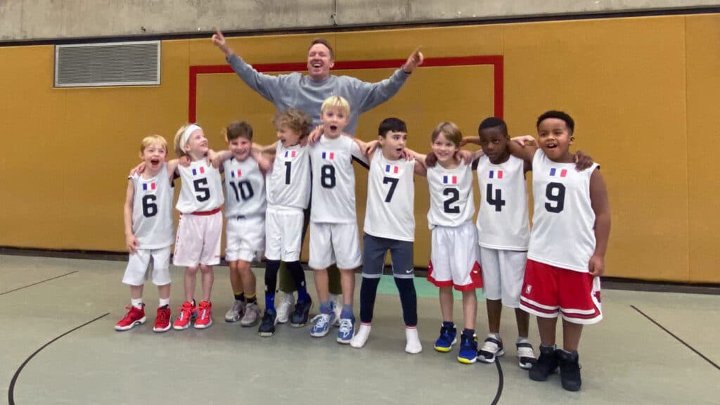 Kinderbasketballteam der RheinStars Köln jubelt in der Sporthalle.