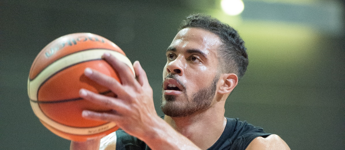 Basketballspieler der RheinStars Köln beim Freiwurftraining mit konzentriertem Blick.