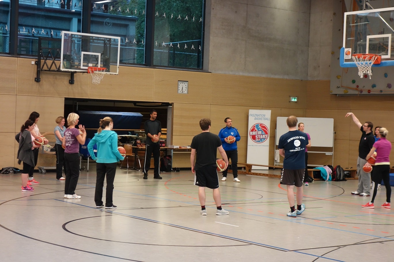 Basketballtraining der RheinStars Köln in einer Sporthalle mit Teilnehmern verschiedenen Alters.