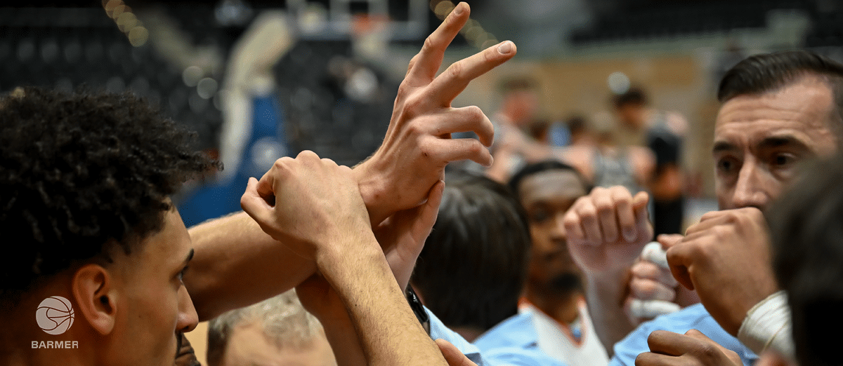 Spieler der RheinStars Köln geben sich gegenseitig motivierende High-Fives in der Halle.