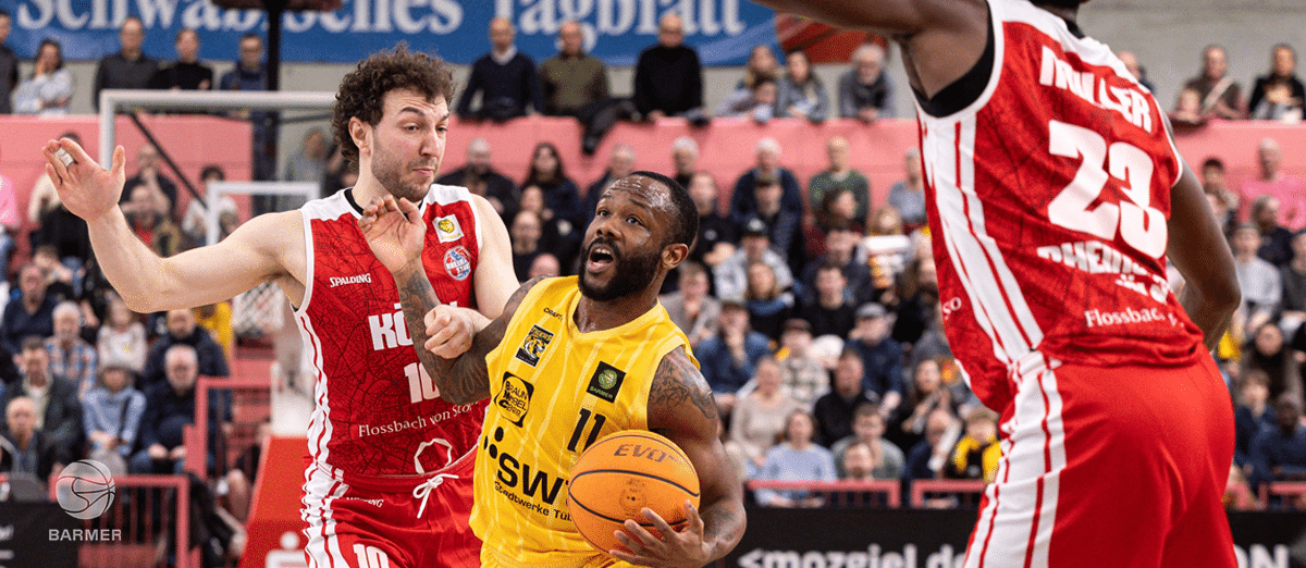 Basketballspiel der RheinStars Köln: Spieler in Gelb mit Ball gegen Gegner in Rot.