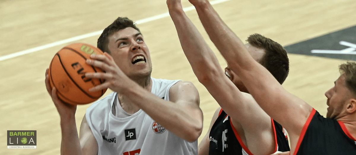 Basketballspieler der RheinStars Köln beim Wurf unter Druck der Verteidigung.