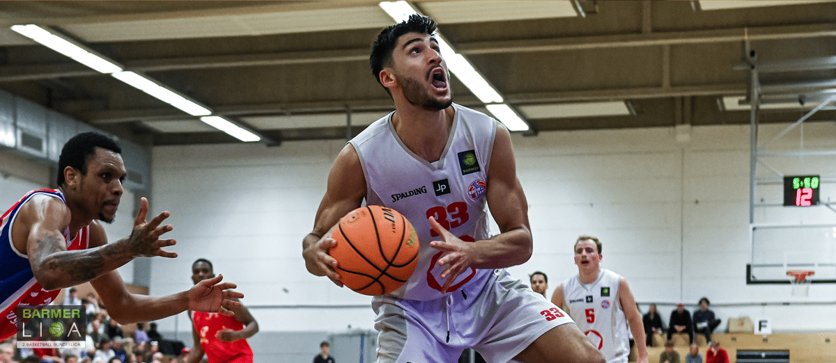 Basketballspieler der RheinStars Köln mit Nummer 39 dribbelt den Ball in der Halle.