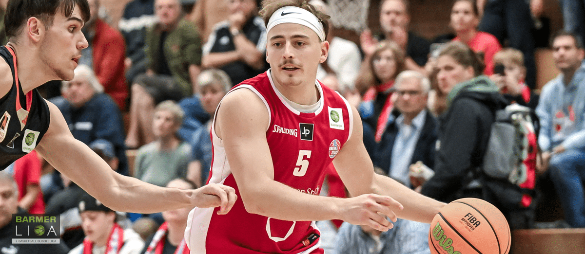 Basketballspieler der RheinStars Köln in rotem Trikot Nummer 5 dribbelt während eines Spiels.